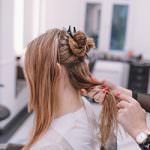 A woman getting her hair styled after it has been washed.
