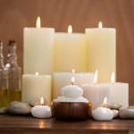 A set of different shaped candles, all list with a calm flame.